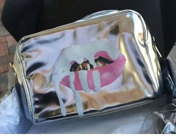 Silver zipped makeup bag alongside eyeshadow palette for storage